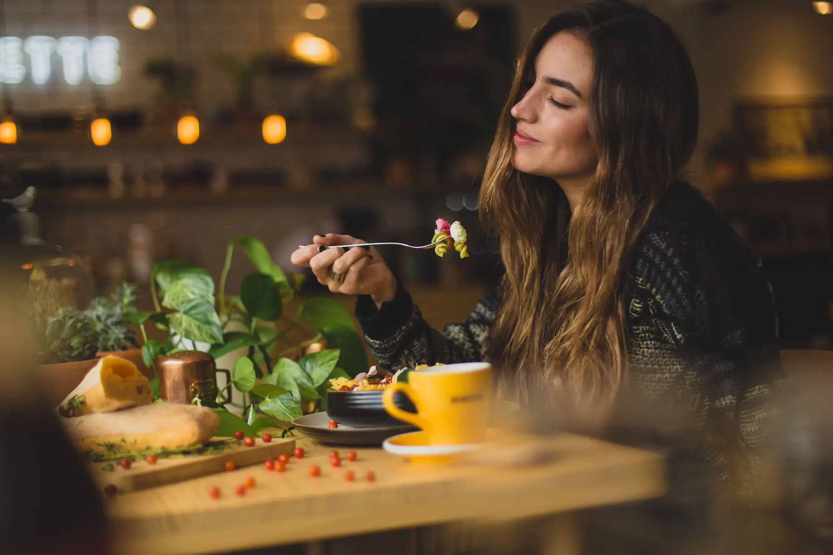 Une femme savoure son repas, attablée dans un café